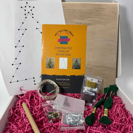 Open box with board, nails, string, lights, instructions, ornaments and template.