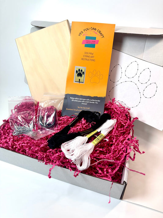 Dog Paw String Art Kit with wooden board, black and white thread, nails, hook, and instructions for crafting; similar to a Christmas Tree String Art Kit in DIY concept.
