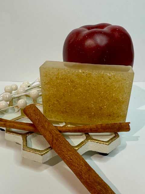 Bar of soap with an apple and cinnamon stick on a white background