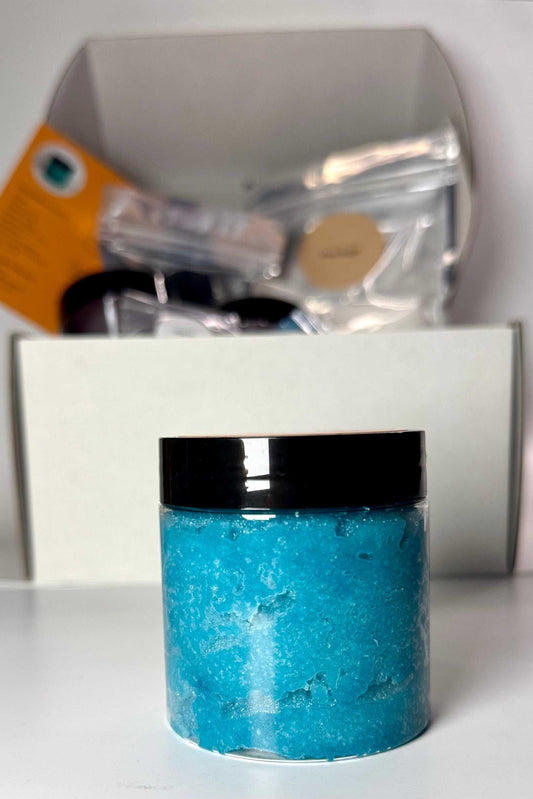 Blue Raspberry Sugar Scrub in a clear jar, showing bright turquoise-blue grainy scrub beneath a black lid