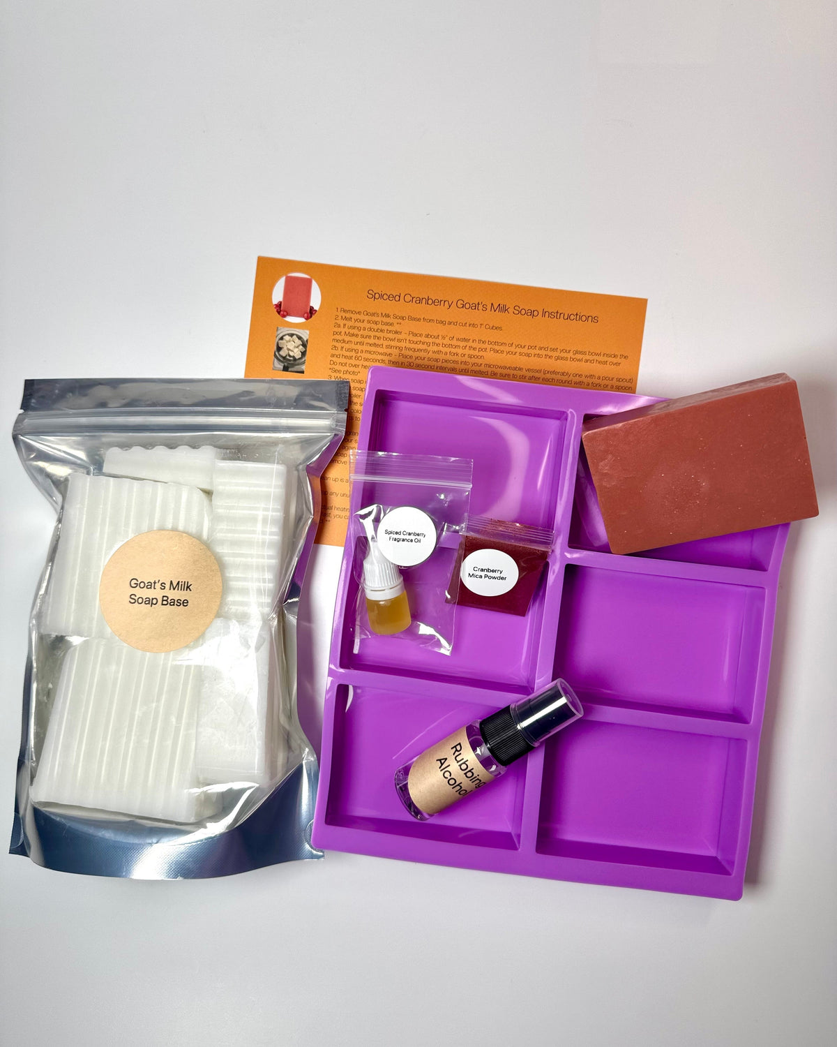 Spiced Cranberry Soap Making Kit with white goat’s milk soap base, soap mold, fragrance oils, and cranberry colored soap bar